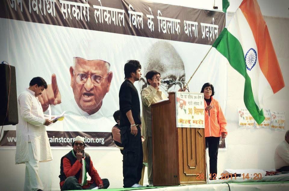 Kashish Kumar on the India Against Corruption stage with Dr. Kiran Bedi, Anna Hazare on the banner behind